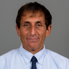 Donald Siegel headshot - medium-skinned man, brown hair, blue collared shirt, navy tie